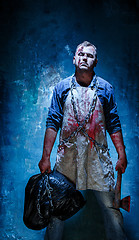 Image showing Bloody Halloween theme: crazy killer as butcher with an ax