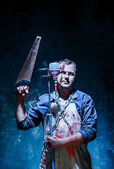 Image showing Bloody Halloween theme: crazy killer as butcher with saw