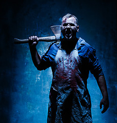 Image showing Bloody Halloween theme: crazy killer as butcher with an ax