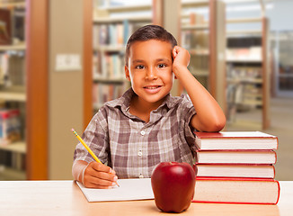 Image showing Hispanic Boy with Books, Apple, Pencil and Paper at Library