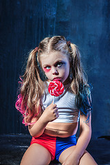 Image showing The funny crasy girl with candy on dark background