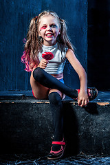 Image showing The funny crasy girl with candy on dark background