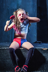 Image showing The funny crasy girl with candy on dark background