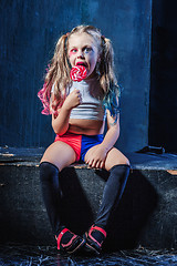 Image showing The funny crasy girl with candy on dark background