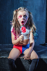 Image showing The funny crasy girl with candy on dark background