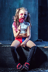 Image showing The funny crasy girl with candy on dark background