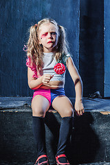 Image showing The crasy girl with candy on dark background