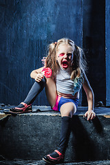 Image showing The crasy girl with candy on dark background