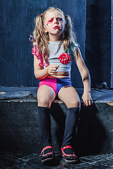 Image showing The crasy girl with candy on dark background