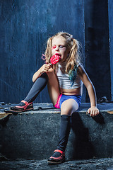 Image showing The crasy girl with candy on dark background