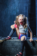 Image showing The crasy girl with candy on dark background