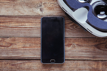 Image showing Modern smartphone with empty screen and virtual reality goggles