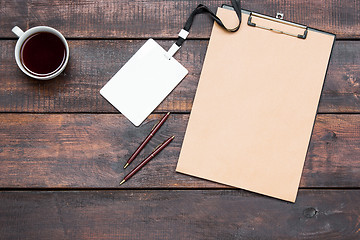 Image showing Office wooden table with pens, tablet for notes and cup