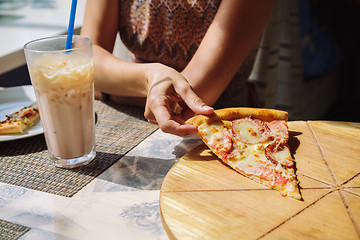 Image showing Unrecognizable woman eating pizza in cafe