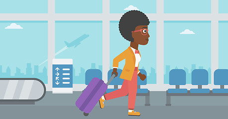 Image showing Woman walking with suitcase at the airport.