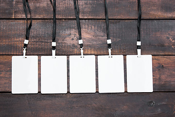 Image showing The five card badges with ropes on wooden table