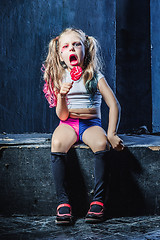 Image showing The funny crasy girl with candy on dark background