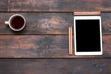 Image showing Office desk table with laptop, pencils and coffee cup.