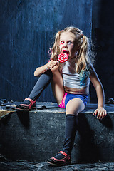 Image showing The funny crasy girl with candy on dark background