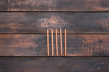 Image showing Colored wooden pencils on a wooden old background.