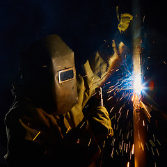 Image showing welder worker welding metal by electrode