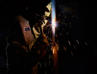 Image showing welder worker welding metal by electrode