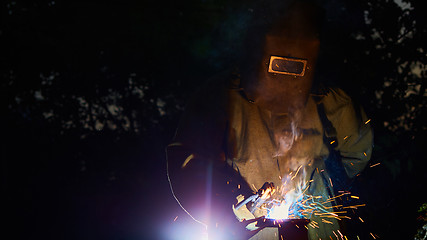 Image showing welder worker welding metal by electrode