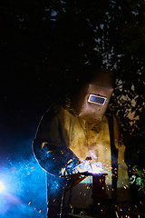 Image showing welder worker welding metal by electrode