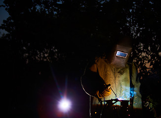 Image showing welder worker welding metal by electrode