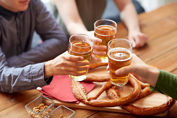 Image showing close up of hands clinking beer at bar or pub