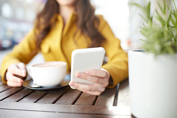 Image showing close up of woman texting on smartphone at cafe