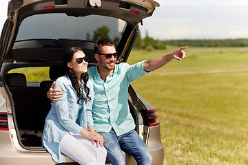 Image showing happy couple hugging at open hatchback car trunk