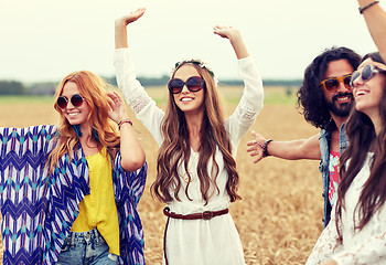 Image showing happy young hippie friends dancing on cereal field