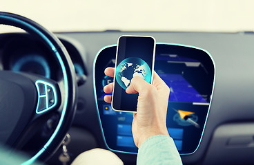 Image showing close up of man hand with smartphone driving car