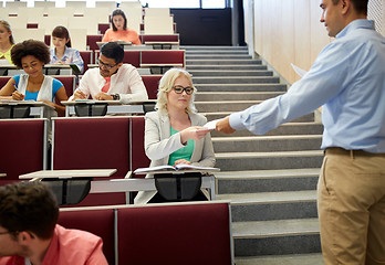 Image showing teacher giving exam tests to students at lecture