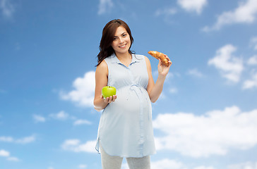 Image showing happy pregnant woman with apple and croissant