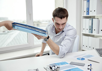 Image showing businessman taking papers from secretary in office