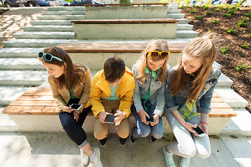 Image showing happy teenage friends with smartphones outdoors