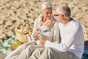 Image showing happy senior couple having picnic on summer beach