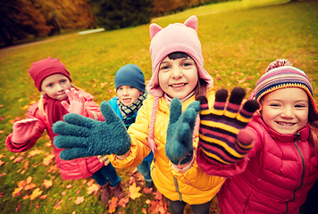 Image showing happy children waving hands in autumn park