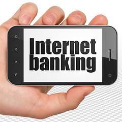 Image showing Currency concept: Hand Holding Smartphone with Internet Banking on display
