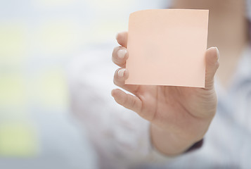 Image showing Hand of woman holding sticky note with empty space