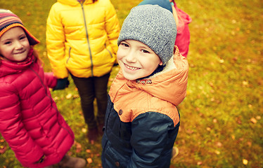 Image showing children holding hands and playing in autumn park