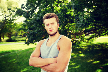 Image showing sporty young man with crossed arms at summer park