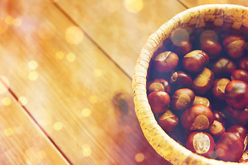 Image showing close up of chestnuts in basket on wooden table