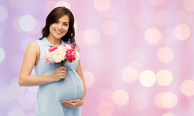 Image showing happy pregnant woman with flowers touching belly