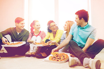 Image showing five smiling teenagers eating pizza at home