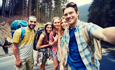 Image showing friends with backpack taking selfie in wood