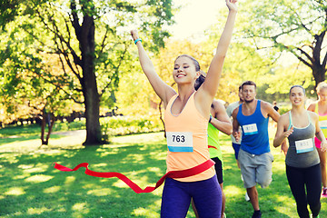 Image showing happy young female runner winning on race finish