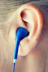 Image showing close up of woman in earphones at home